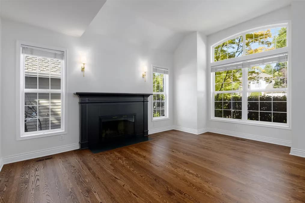 After photo of the renovated Lake Oswego home showing the completed kitchen with curved island, stainless appliances, and modern pendant lighting by Tortoise Construction LLC
